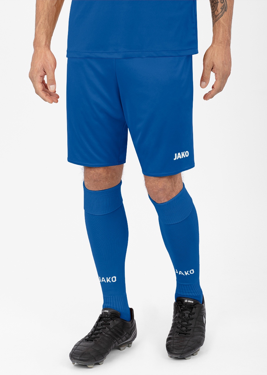Person wearing blue JAKO soccer kit: shorts, matching knee-high socks, and black cleats visible from waist to feet.